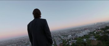 Movie still from “Knight of Cups” (2015), directed by Terrence Malick – A man in a suit looking out over a city; Wide shot, Low angle