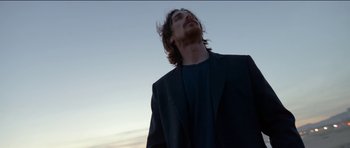 Movie still from “Knight of Cups” (2015), directed by Terrence Malick – A man with long hair and a beard is looking up; Medium shot, Low angle