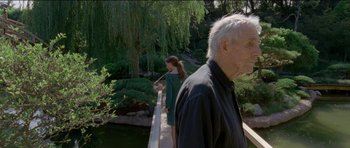 Movie still from “Knight of Cups” (2015), directed by Terrence Malick – An older man and a younger woman standing on a bridge; Medium shot, Over the shoulder angle