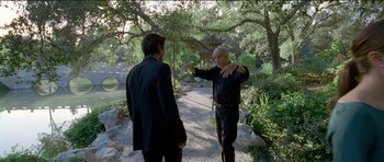Movie still from “Knight of Cups” (2015), directed by Terrence Malick – Two men are talking on a path in the woods; Wide shot, Over the shoulder angle