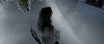 Movie still from “Knight of Cups” (2015), directed by Terrence Malick – A woman holding a tennis racquet under a cloudy sky; Medium shot, High angle