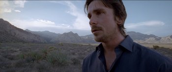 Movie still from “Knight of Cups” (2015), directed by Terrence Malick – A person in a field with mountains in the background; Close Up shot, Low angle