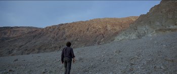Movie still from “Knight of Cups” (2015), directed by Terrence Malick – A man is standing on a rocky mountain side; Extreme Wide shot, Low angle
