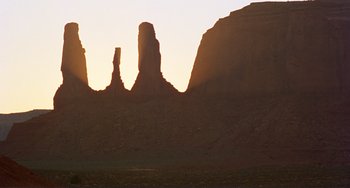 Movie still from “Koyaanisqatsi” (1982), directed by Godfrey Reggio – The sun is setting over a rock formation; Extreme Wide shot, Low angle