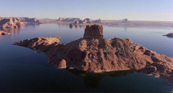 Movie still from “Koyaanisqatsi” (1982), directed by Godfrey Reggio – A body of water that has some rocks in it; Extreme Wide shot, High angle