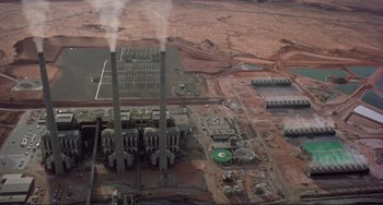 Movie still from “Koyaanisqatsi” (1982), directed by Godfrey Reggio – An aerial view of an industrial area with a power plant; Extreme Wide shot, High angle