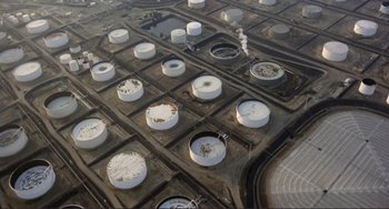 Movie still from “Koyaanisqatsi” (1982), directed by Godfrey Reggio – An aerial view of oil storage tanks in an oil field; Extreme Wide shot, Overhead angle
