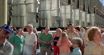 Movie still from “Koyaanisqatsi” (1982), directed by Godfrey Reggio – A group of people standing next to each other; Wide shot, Low angle