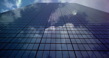 Movie still from “Koyaanisqatsi” (1982), directed by Godfrey Reggio – A view of a skyscraper from the ground looking up; Extreme Wide shot, Low angle