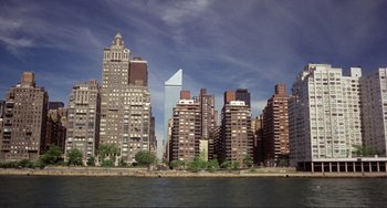 Movie still from “Koyaanisqatsi” (1982), directed by Godfrey Reggio – A view of a city skyline from across the water; Extreme Wide shot, High angle