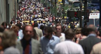 Movie still from “Koyaanisqatsi” (1982), directed by Godfrey Reggio – A crowd of people walking down a busy street; Extreme Wide shot, High angle