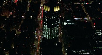 Movie still from “Koyaanisqatsi” (1982), directed by Godfrey Reggio – An aerial view of a building lit up at night; Extreme Wide shot, Overhead angle