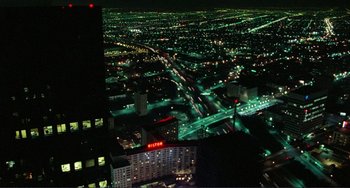 Movie still from “Koyaanisqatsi” (1982), directed by Godfrey Reggio – An aerial view of a city lit up at night; Extreme Wide shot, High angle