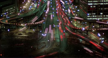 Movie still from “Koyaanisqatsi” (1982), directed by Godfrey Reggio – An aerial view of a busy highway at night; Extreme Wide shot, High angle