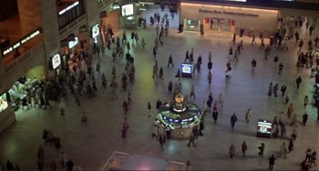 Movie still from “Koyaanisqatsi” (1982), directed by Godfrey Reggio – A crowd of people walking around a building at night; Extreme Wide shot, High angle