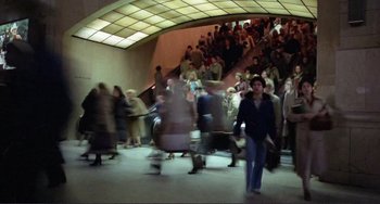 Movie still from “Koyaanisqatsi” (1982), directed by Godfrey Reggio – A crowd of people walking down a flight of stairs; Wide shot, High angle