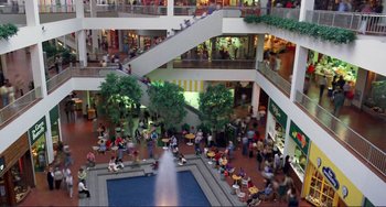 Movie still from “Koyaanisqatsi” (1982), directed by Godfrey Reggio – A large group of people in an indoor shopping mall; Extreme Wide shot, High angle