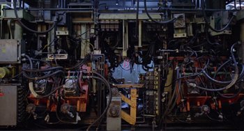 Movie still from “Koyaanisqatsi” (1982), directed by Godfrey Reggio – An industrial machine with many wires attached to it; Wide shot, Low angle