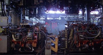 Movie still from “Koyaanisqatsi” (1982), directed by Godfrey Reggio – A room filled with lots of wires and wires; Wide shot, High angle