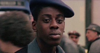 Movie still from “Koyaanisqatsi” (1982), directed by Godfrey Reggio – A person wearing a hat; Close Up shot, Low angle