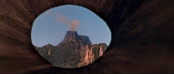 Movie still from “Krakatoa: East of Java” (1968), directed by Bernard L. Kowalski – A view of a mountain from inside of a tunnel; Extreme Close Up shot, Low angle