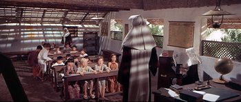 Movie still from “Krakatoa: East of Java” (1968), directed by Bernard L. Kowalski – A nun is standing in front of a group of children; Wide shot, High angle