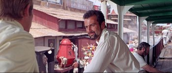 Movie still from “Krakatoa: East of Java” (1968), directed by Bernard L. Kowalski – A man standing on top of a building next to a red fire hydrant; Close Up shot, Low angle