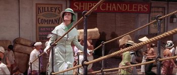 Movie still from “Krakatoa: East of Java” (1968), directed by Bernard L. Kowalski – A woman wearing a green hat and a green dress; Medium shot, Low angle