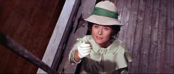 Movie still from “Krakatoa: East of Java” (1968), directed by Bernard L. Kowalski – A woman wearing a hat and gloves pointing at the camera; Close Up shot, Low angle