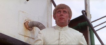 Movie still from “Krakatoa: East of Java” (1968), directed by Bernard L. Kowalski – A person wearing a white shirt; Close Up shot, Low angle