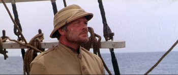 Movie still from “Krakatoa: East of Java” (1968), directed by Bernard L. Kowalski – A person wearing a hat on a boat; Close Up shot, Low angle