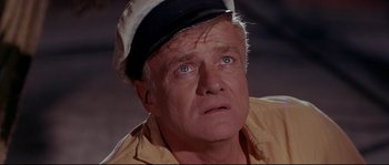 Movie still from “Krakatoa: East of Java” (1968), directed by Bernard L. Kowalski – An older man wearing a sailor's hat and looking at the camera; Close Up shot, High angle