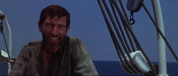 Movie still from “Krakatoa: East of Java” (1968), directed by Bernard L. Kowalski – A man sitting on the deck of a boat in the ocean; Close Up shot, Low angle