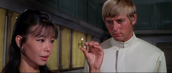 Movie still from “Krakatoa: East of Java” (1968), directed by Bernard L. Kowalski – A man and a woman looking at a piece of paper; Close Up shot, Over the shoulder angle