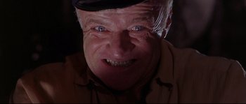 Movie still from “Krakatoa: East of Java” (1968), directed by Bernard L. Kowalski – An old man with a hat and a smirk on his face; Close Up shot, Low angle