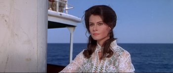 Movie still from “Krakatoa: East of Java” (1968), directed by Bernard L. Kowalski – A woman in a white shirt is sitting on a boat; Close Up shot, Low angle