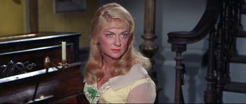 Movie still from “Krakatoa: East of Java” (1968), directed by Bernard L. Kowalski – A woman with long blonde hair wearing a yellow shirt; Close Up shot, Over the shoulder angle
