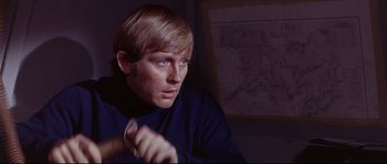 Movie still from “Krakatoa: East of Java” (1968), directed by Bernard L. Kowalski – A man sitting in front of a map in a dark room; Close Up shot, High angle