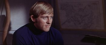 Movie still from “Krakatoa: East of Java” (1968), directed by Bernard L. Kowalski – A man with blonde hair wearing a blue sweater; Close Up shot, High angle