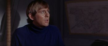 Movie still from “Krakatoa: East of Java” (1968), directed by Bernard L. Kowalski – A man in a blue sweater is looking at the camera; Close Up shot, Over the shoulder angle