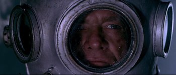 Movie still from “Krakatoa: East of Java” (1968), directed by Bernard L. Kowalski – A man's face through a mirror; Close Up shot, Overhead angle