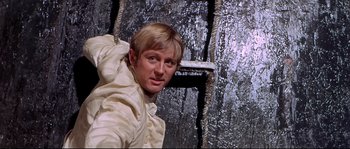 Movie still from “Krakatoa: East of Java” (1968), directed by Bernard L. Kowalski – A man standing in front of a wall with ropes; Close Up shot, High angle