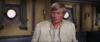 Movie still from “Krakatoa: East of Java” (1968), directed by Bernard L. Kowalski – A person wearing a suit and tie; Close Up shot, Over the shoulder angle