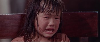 Movie still from “Krakatoa: East of Java” (1968), directed by Bernard L. Kowalski – A little girl with wet hair crying; Close Up shot, High angle