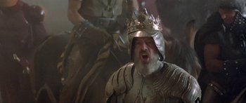 Movie still from “Krull” (1983), directed by Peter Yates – A man with a beard wearing a crown and armor; Medium shot, Low angle