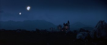 Movie still from “Krull” (1983), directed by Peter Yates – A group of people standing on top of a hill at night; Extreme Wide shot, Low angle