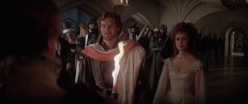 Movie still from “Krull” (1983), directed by Peter Yates – A group of people standing in a room with swords; Medium shot, Over the shoulder angle