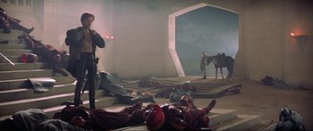 Movie still from “Krull” (1983), directed by Peter Yates – A man standing next to a horse in a room; Wide shot, High angle