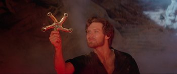Movie still from “Krull” (1983), directed by Peter Yates – A man holding a wrench in his hand; Close Up shot, Overhead angle