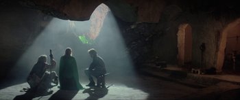 Movie still from “Krull” (1983), directed by Peter Yates – A man and a woman sitting on a bench in a cave; Wide shot, Over the shoulder angle